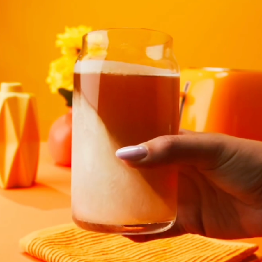 A woman holding a half frozen Teapot based drink