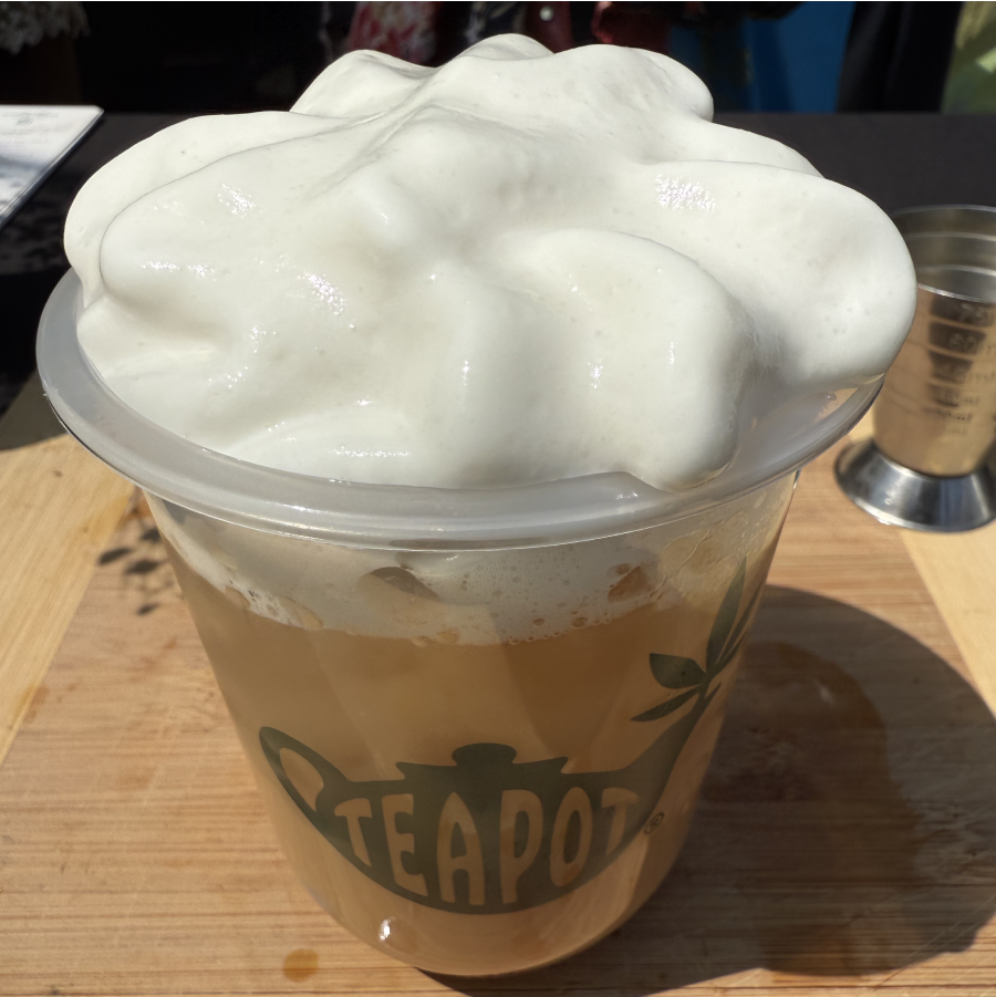 A cup on a table topped with whipped cream.