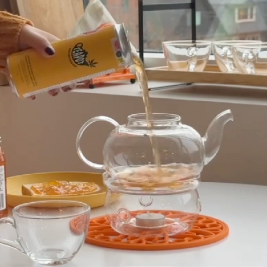 A can of Tea Pot being poured into a teapot on a stove